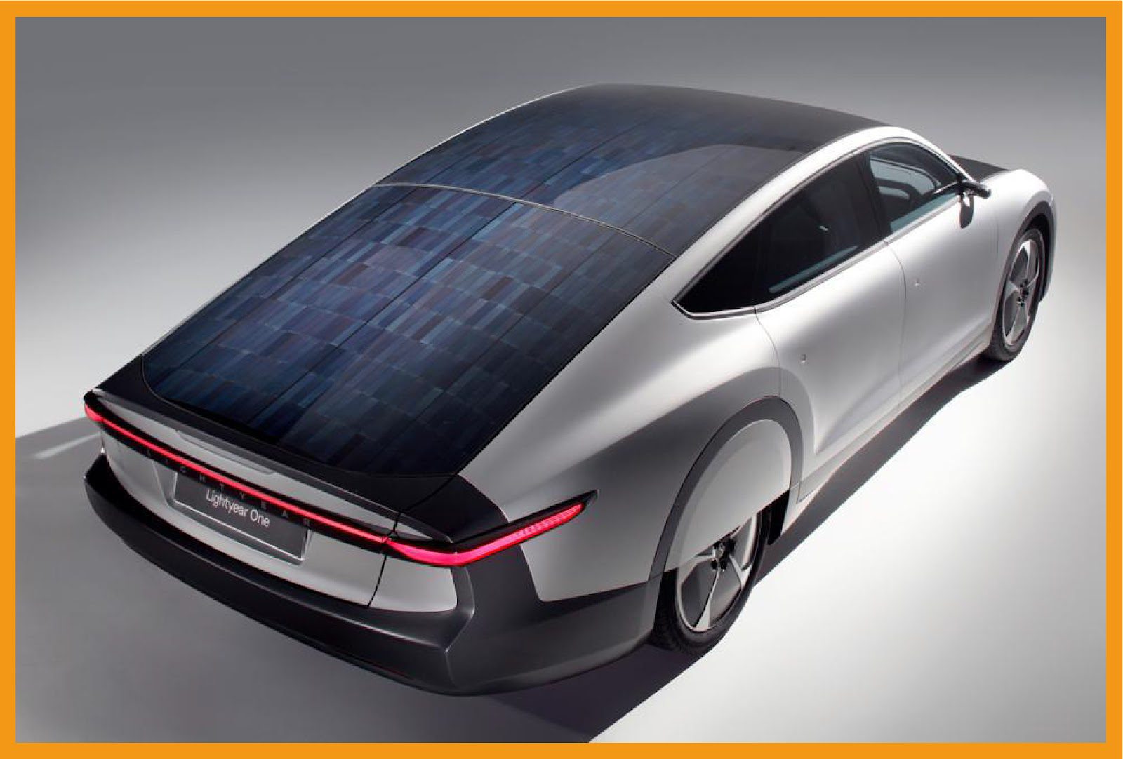 Lightyear 0 solar powered personal car, rear ¾ view with full solar cell coverage of roof and rear visible.